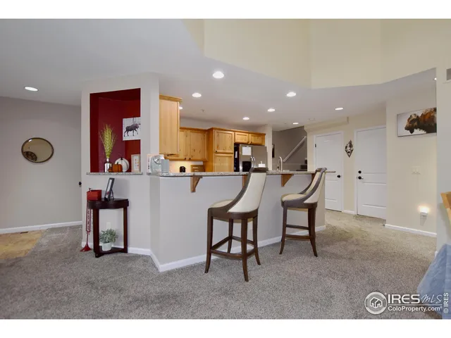 a living room with furniture a flat screen tv and kitchen view