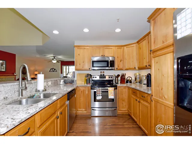 a kitchen with granite countertop a refrigerator and a sink