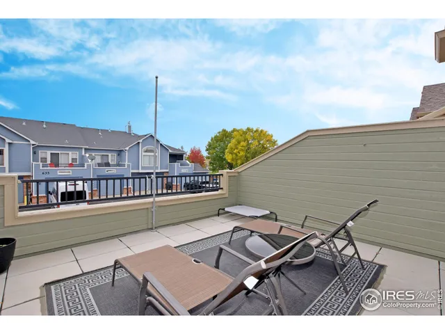 a balcony with table and chairs and wooden floor