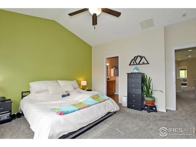 a bedroom with a bed and a flat tv screen on dresser
