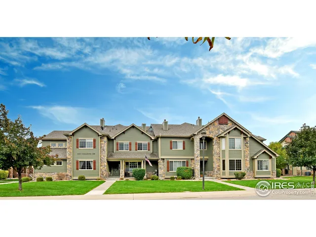a living room with furniture a fireplace and a large window