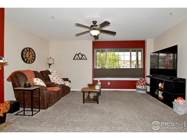 a living room with furniture a flat screen tv and a window