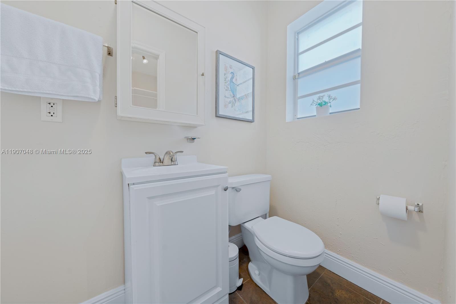 1241 14th Street, Unit 11 Miami Beach, FL 33139 - Photo 17 of 20 a white toilet sitting next to a bathroom sink