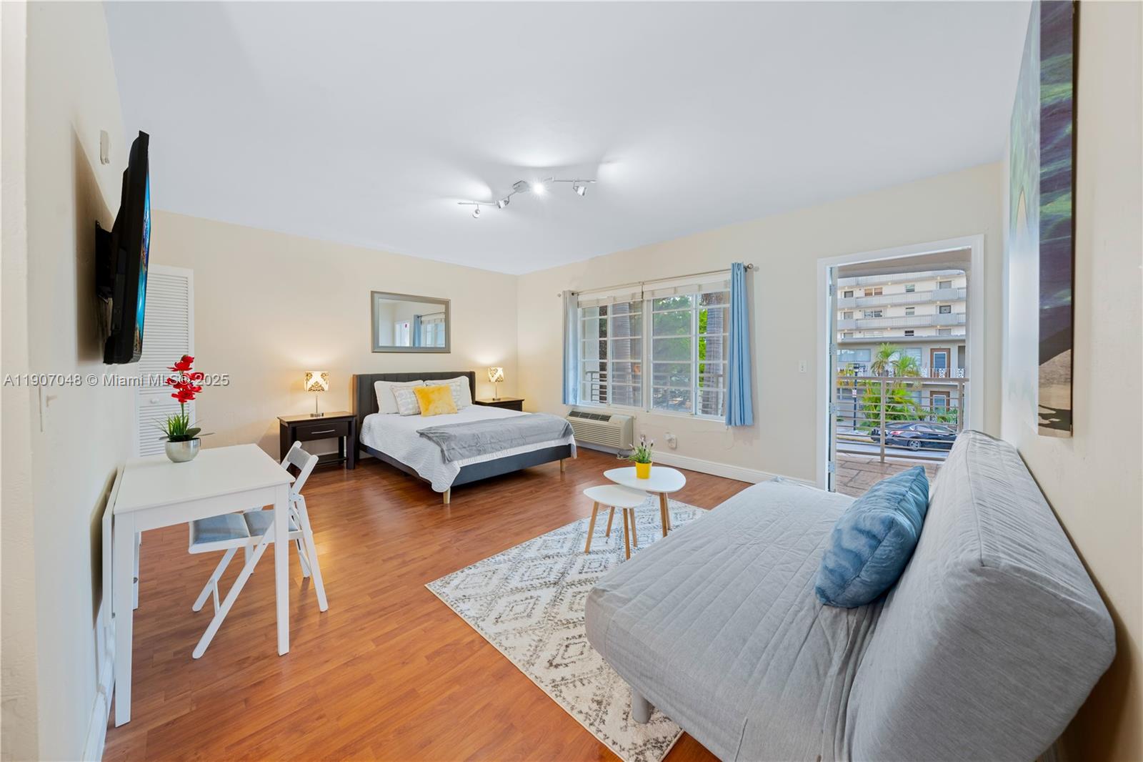 1241 14th Street, Unit 11 Miami Beach, FL 33139 - Photo 3 of 20 a bedroom with furniture and a flat screen tv