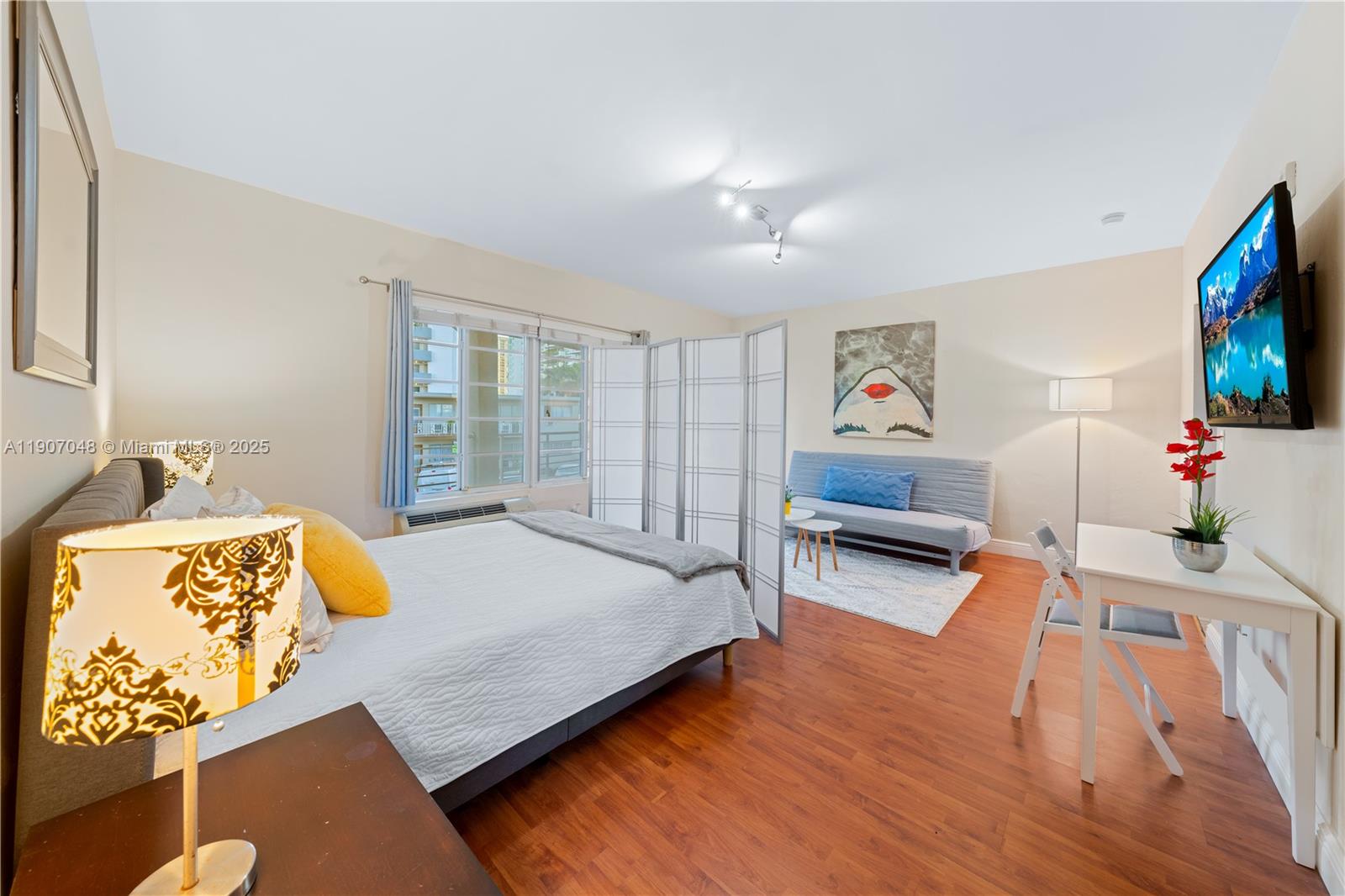 1241 14th Street, Unit 11 Miami Beach, FL 33139 - Photo 6 of 20 a bedroom with furniture and a flat screen tv