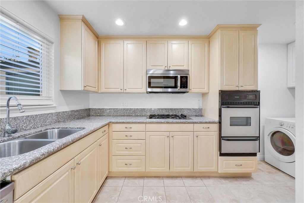 8083 Kerr Green Buena Park, CA 90621 - Photo 16 of 40 a kitchen with granite countertop a sink a stove and cabinets
