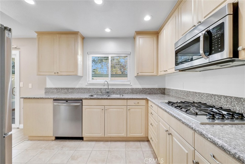 8083 Kerr Green Buena Park, CA 90621 - Photo 17 of 40 a kitchen with stainless steel appliances granite countertop a sink and a stove top oven with granite countertops