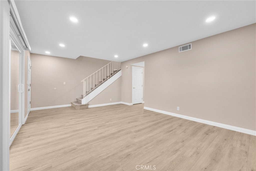 8083 Kerr Green Buena Park, CA 90621 - Photo 9 of 40 an empty room with wooden floor and staircase