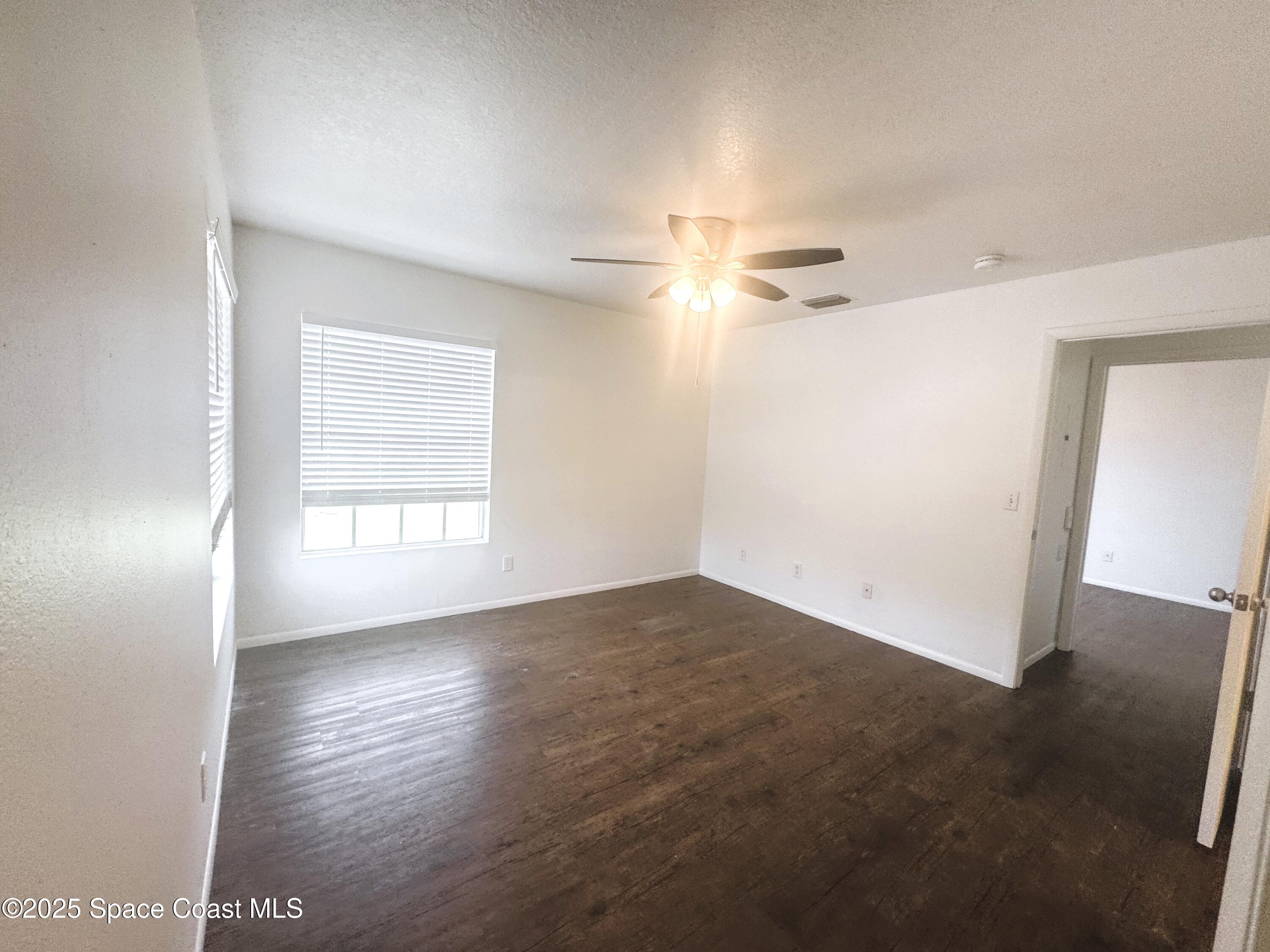 1861 Long Iron Drive, Unit 1121 Rockledge, FL 32955 - Photo 13 of 35 an empty room with wooden floor and windows