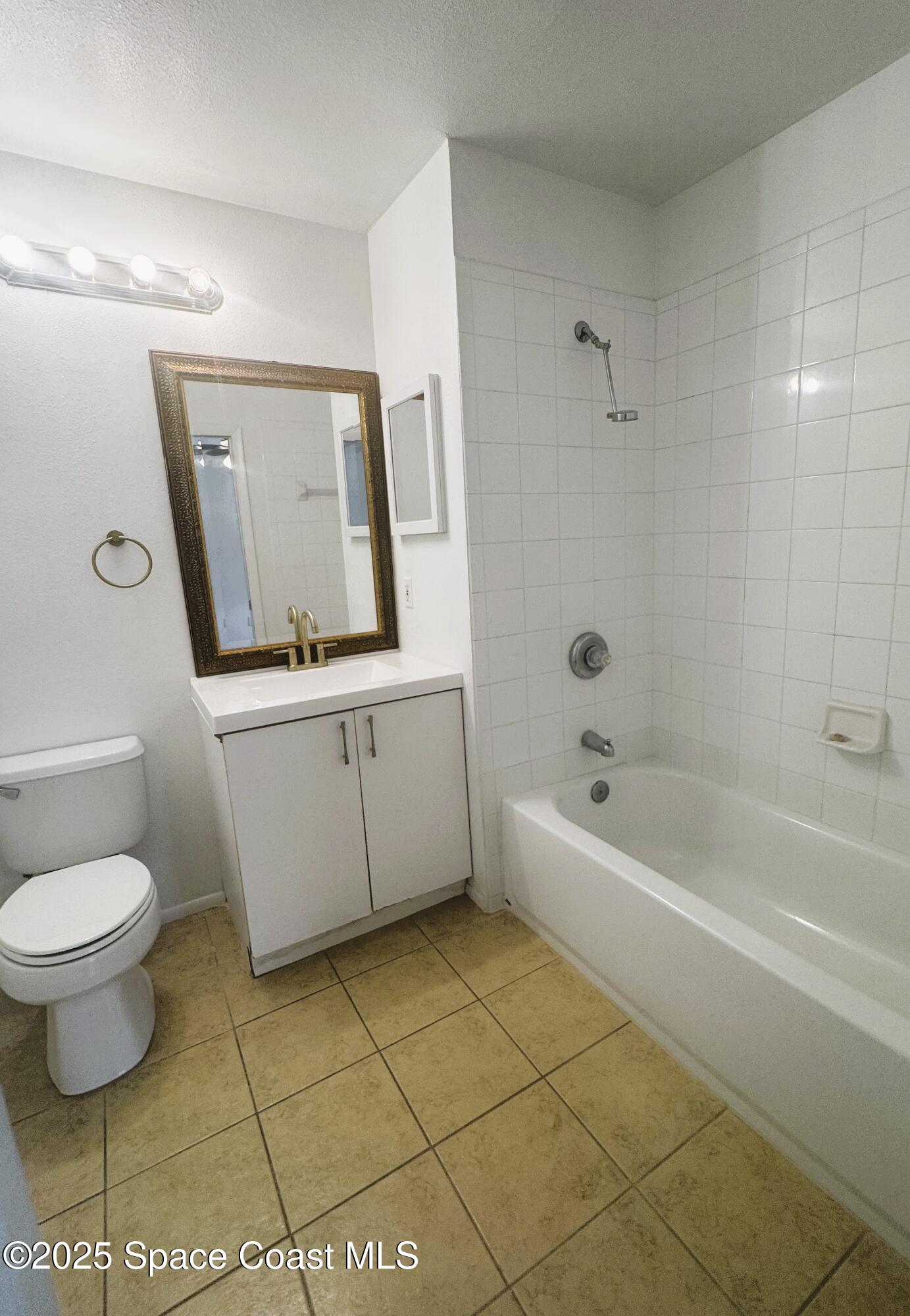 1861 Long Iron Drive, Unit 1121 Rockledge, FL 32955 - Photo 16 of 35 a bathroom with a toilet a sink a mirror and bathtub