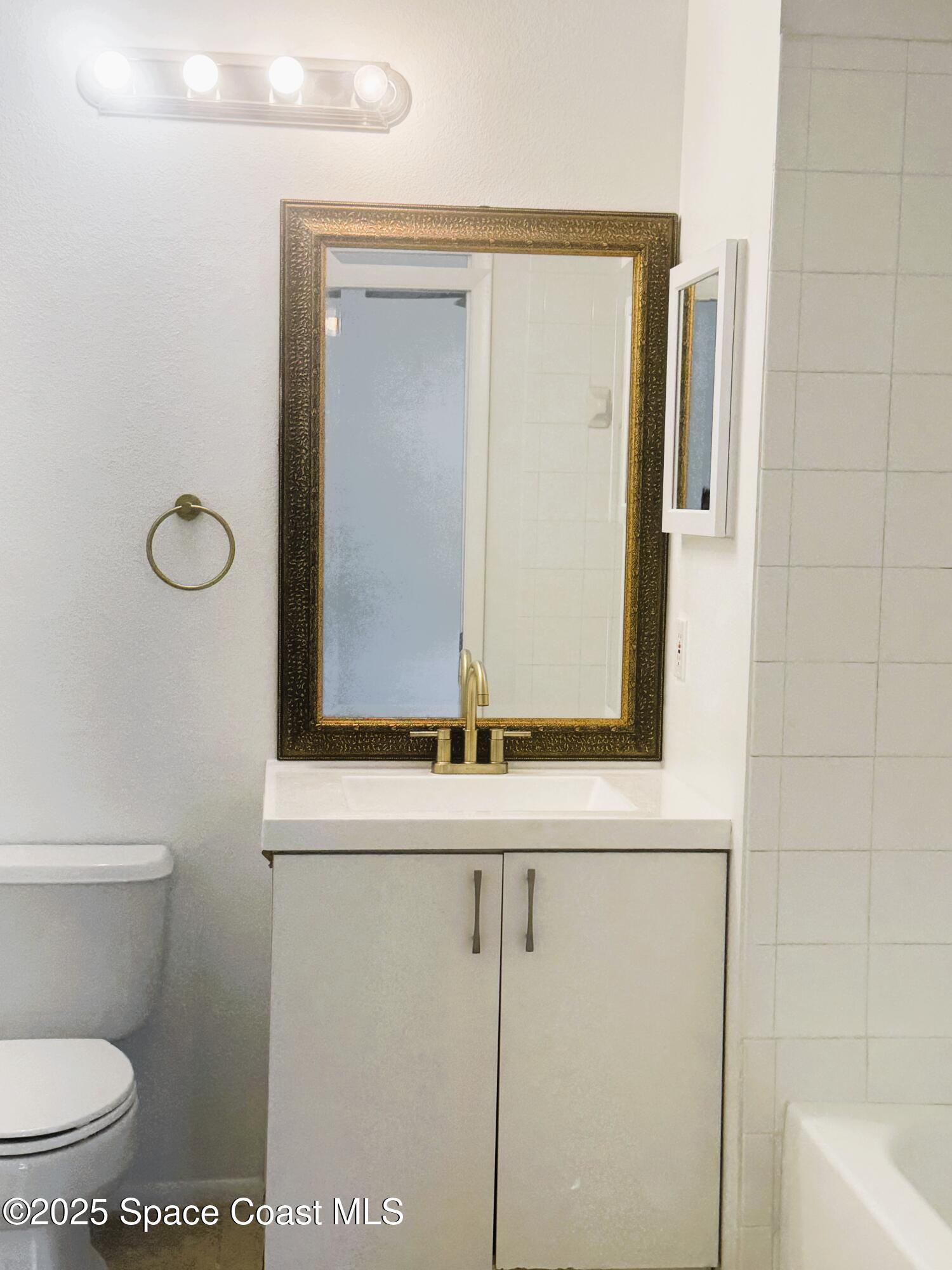 1861 Long Iron Drive, Unit 1121 Rockledge, FL 32955 - Photo 17 of 35 a bathroom with a toilet sink and mirror