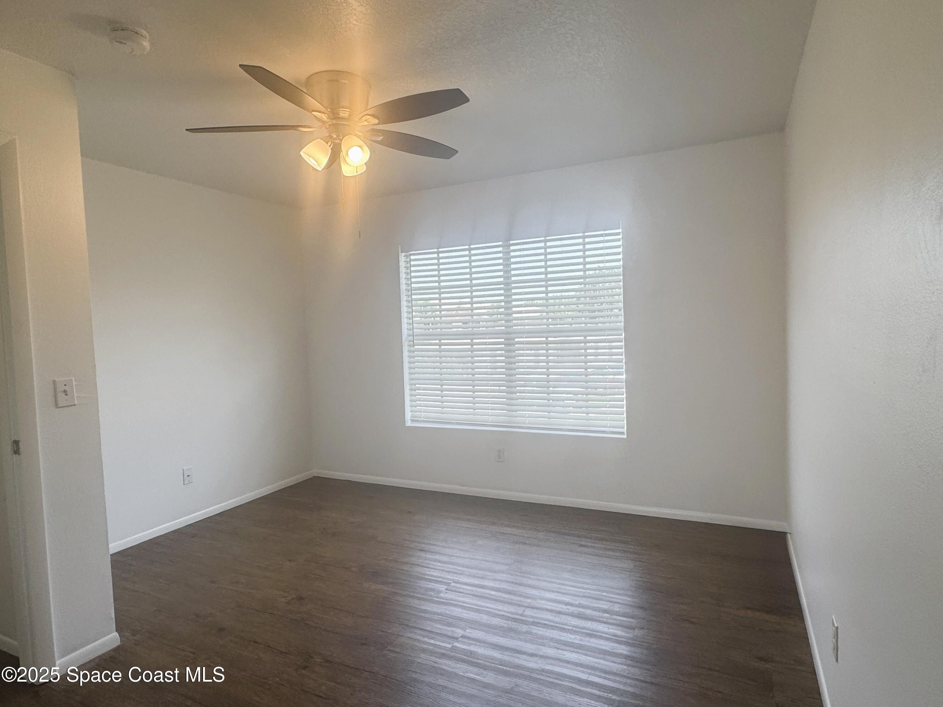 1861 Long Iron Drive, Unit 1121 Rockledge, FL 32955 - Photo 20 of 35 an empty room with wooden floor and windows