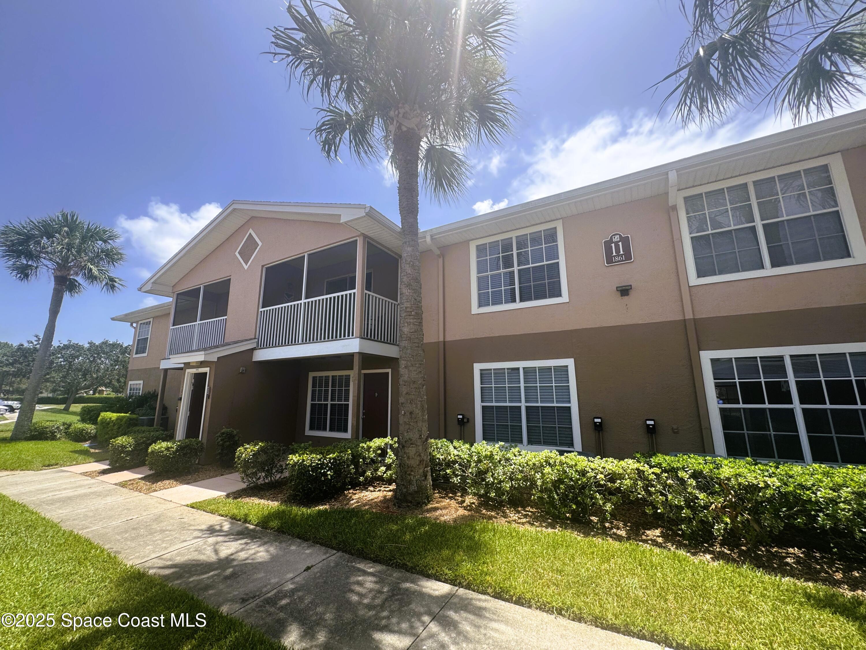 1861 Long Iron Drive, Unit 1121 Rockledge, FL 32955 - Photo 21 of 35 a front view of a house with a yard and potted plants