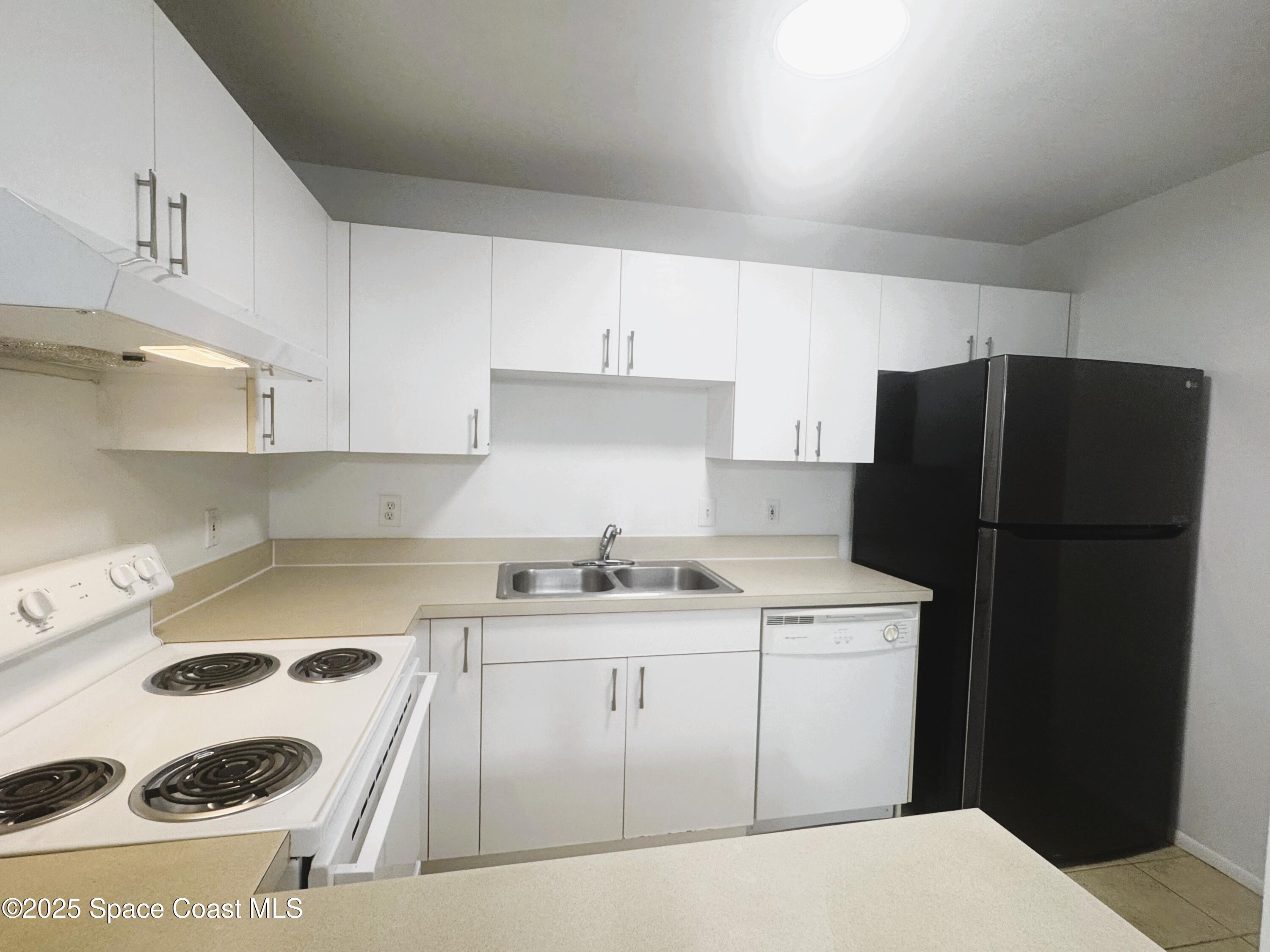 1861 Long Iron Drive, Unit 1121 Rockledge, FL 32955 - Photo 3 of 35 a kitchen with a sink a refrigerator and a stove