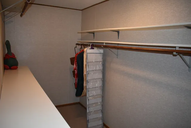 a view of walk in closet with clothes and shoes