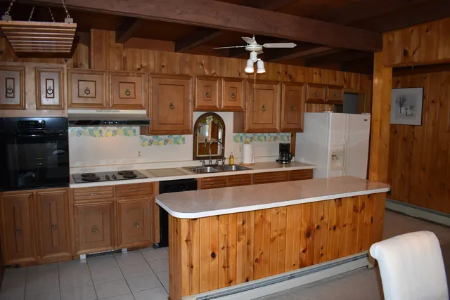 a kitchen with stainless steel appliances granite countertop a sink and a refrigerator