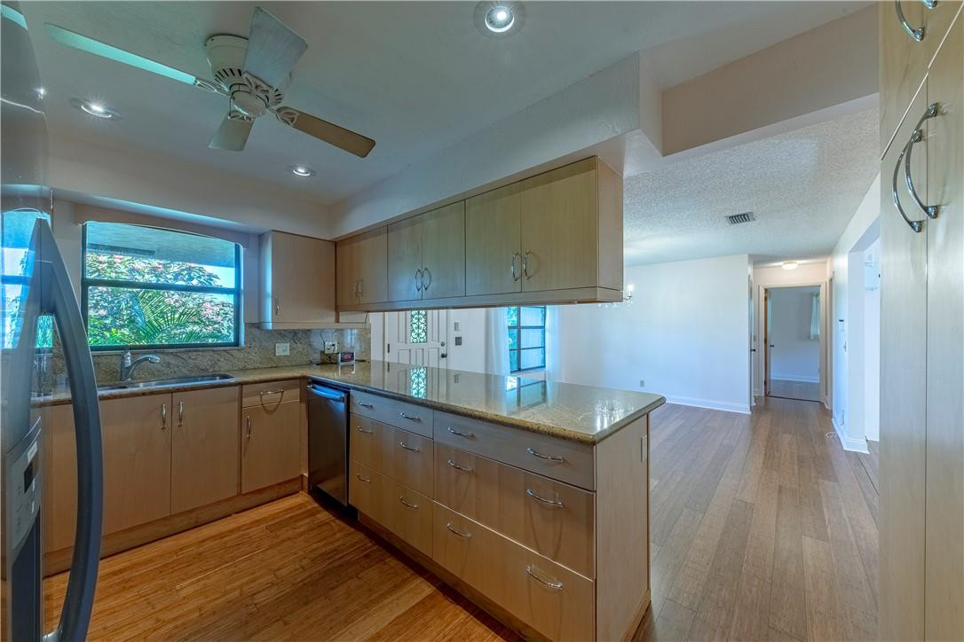 12500 Lake Road Davie, FL 33325 - Photo 14 of 34 a kitchen with stainless steel appliances granite countertop a sink window and cabinets