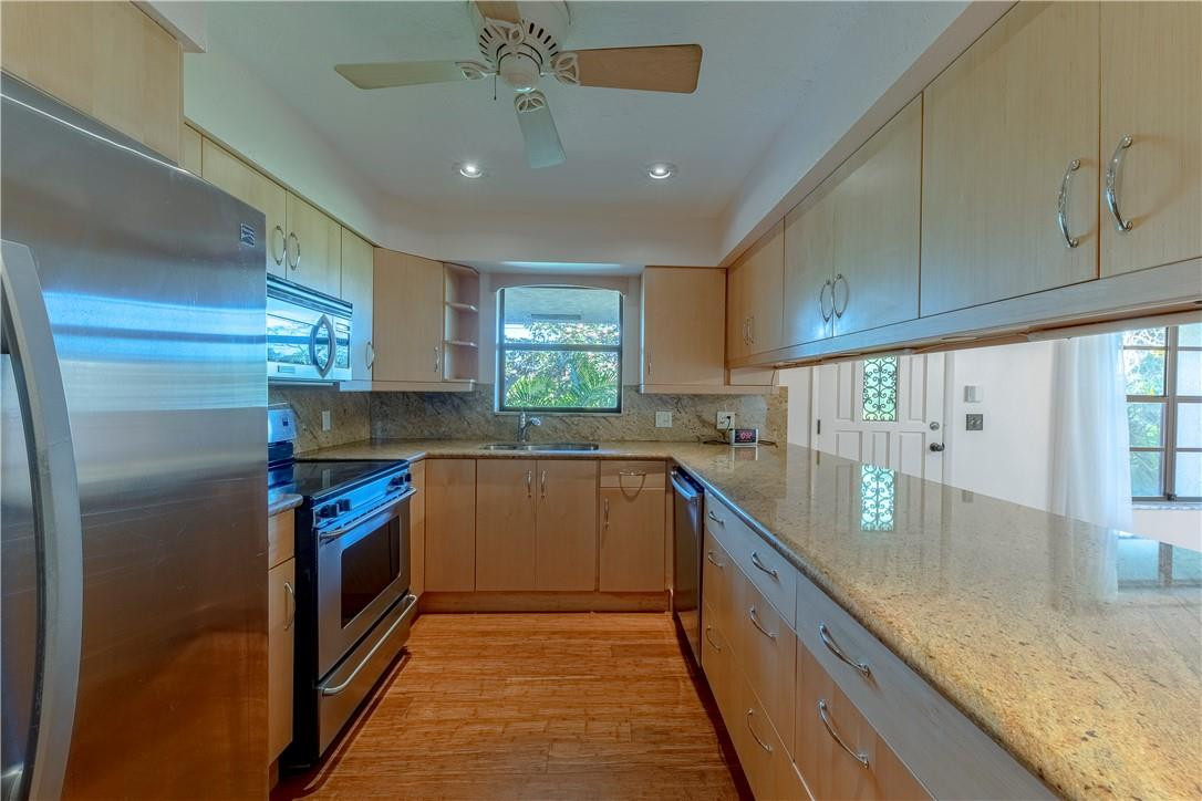 12500 Lake Road Davie, FL 33325 - Photo 15 of 34 a kitchen with stainless steel appliances granite countertop a sink a stove and a refrigerator