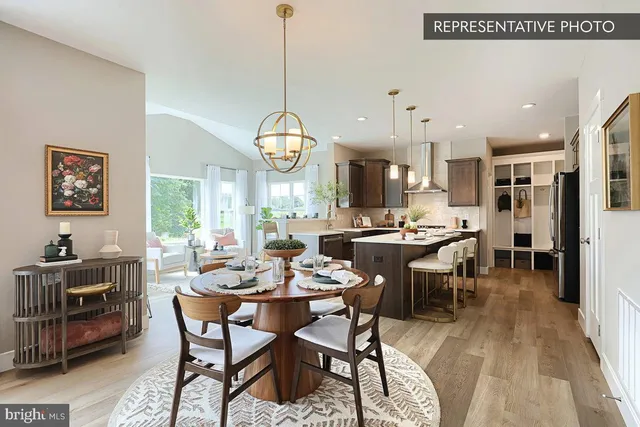 a kitchen with a dining table chairs and white cabinets