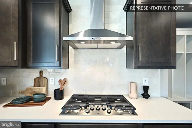 a large kitchen with lots of counter space a sink appliances and living room view