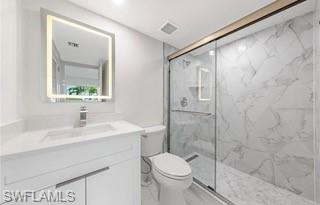 1018 Manatee Road, Unit E107 Naples, FL 34114 - Photo 7 of 15 Bathroom featuring vanity, a marble finish shower, light marble finish flooring, and recessed lighting