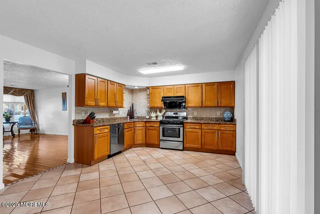 a kitchen with stainless steel appliances granite countertop a refrigerator and a stove top oven