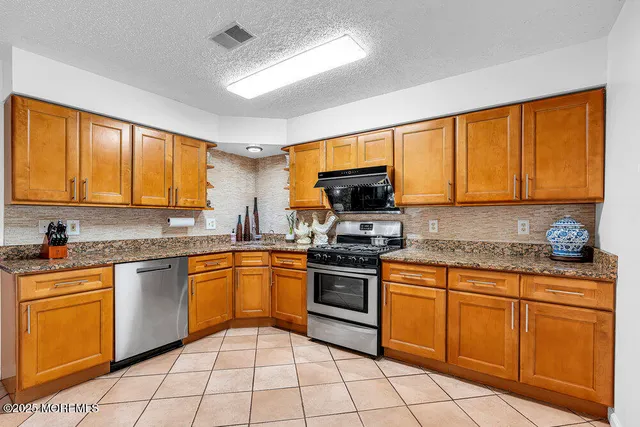 a kitchen with stainless steel appliances granite countertop a stove sink microwave and cabinets