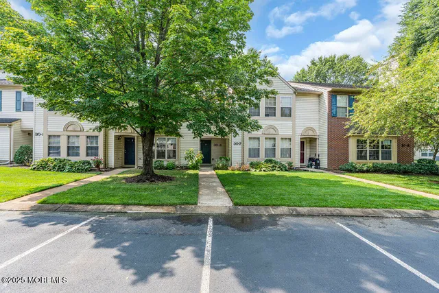 a view of a house with a big yard and large trees