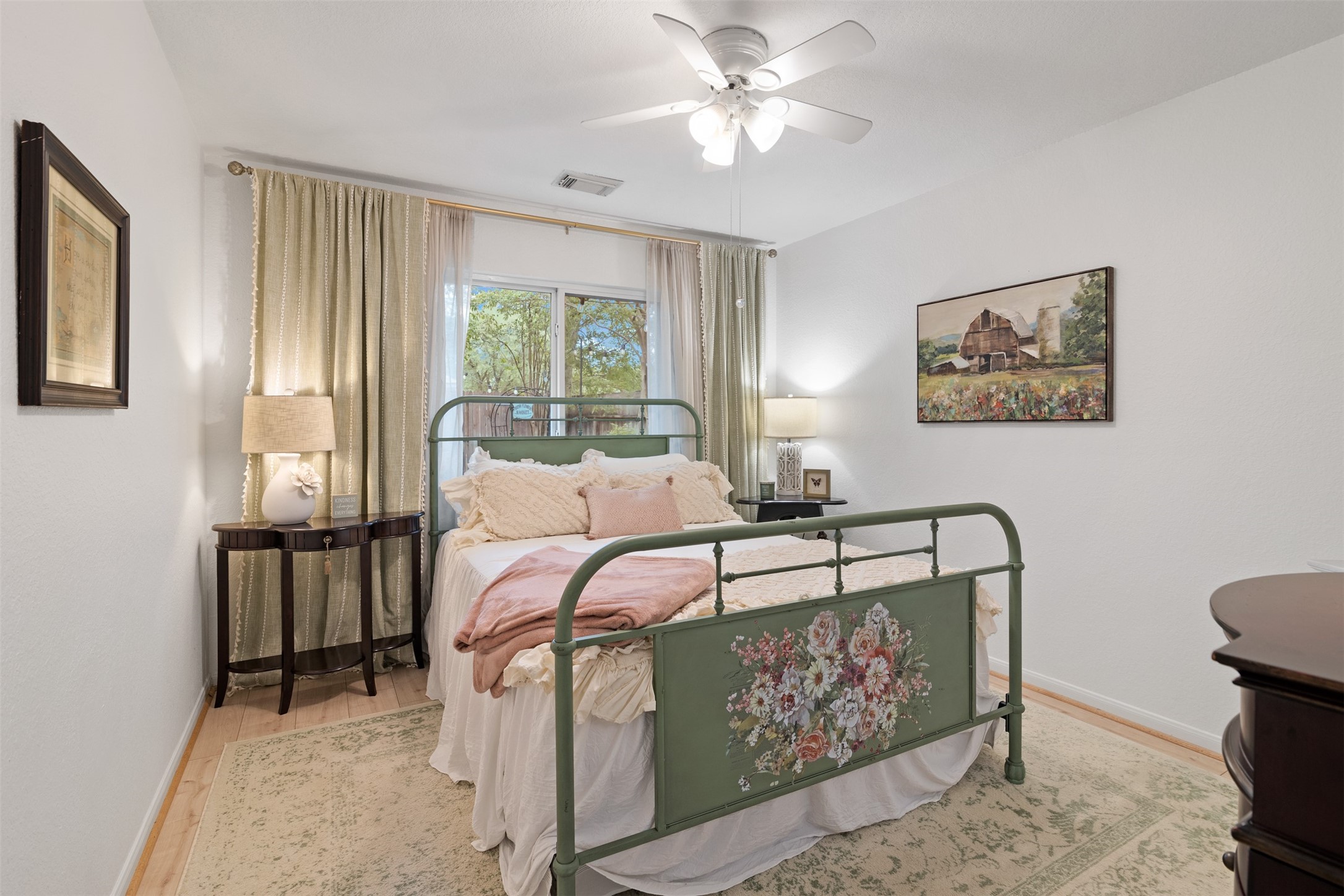 19306 Young Oak Street Spring, TX 77379 - Photo 18 of 28 Secondary bedroom with laminate floors installed in 2023, ceiling fan and large picture window.