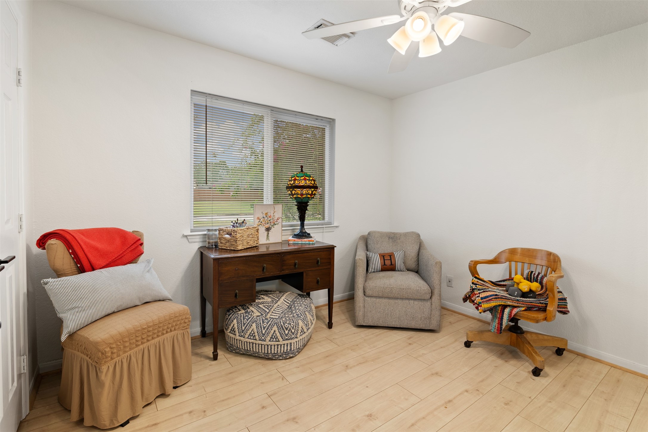 19306 Young Oak Street Spring, TX 77379 - Photo 19 of 28 Another secondary bedroom with laminate floors installed in 2022, ceiling fan and picture window.