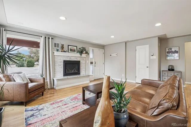 a living room with furniture fireplace and a large window