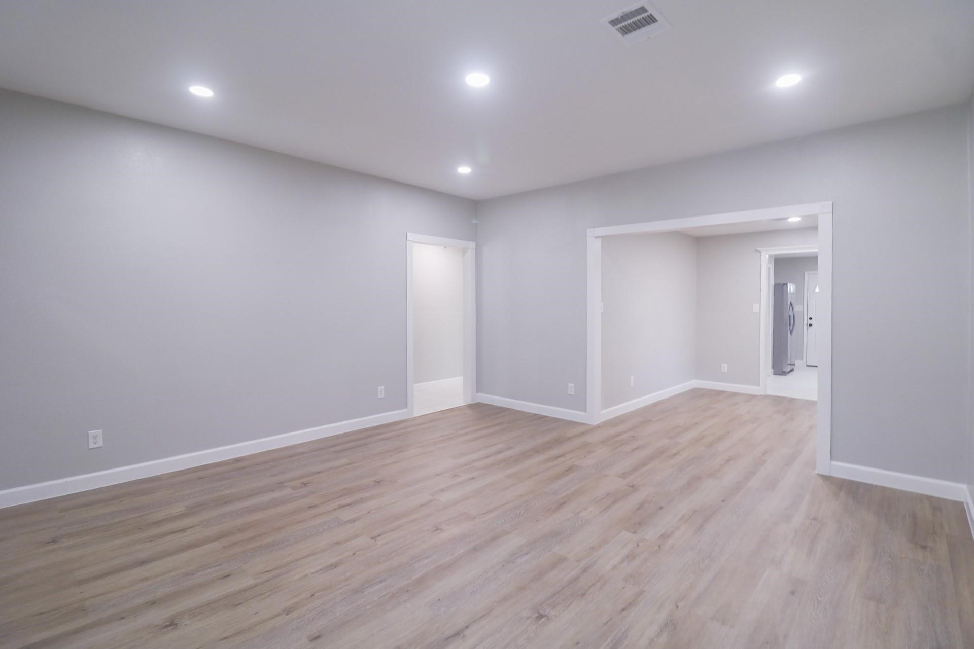 6150 Ridgeway Drive Houston, TX 77033 - Photo 21 of 36 an empty room with wooden floor and windows