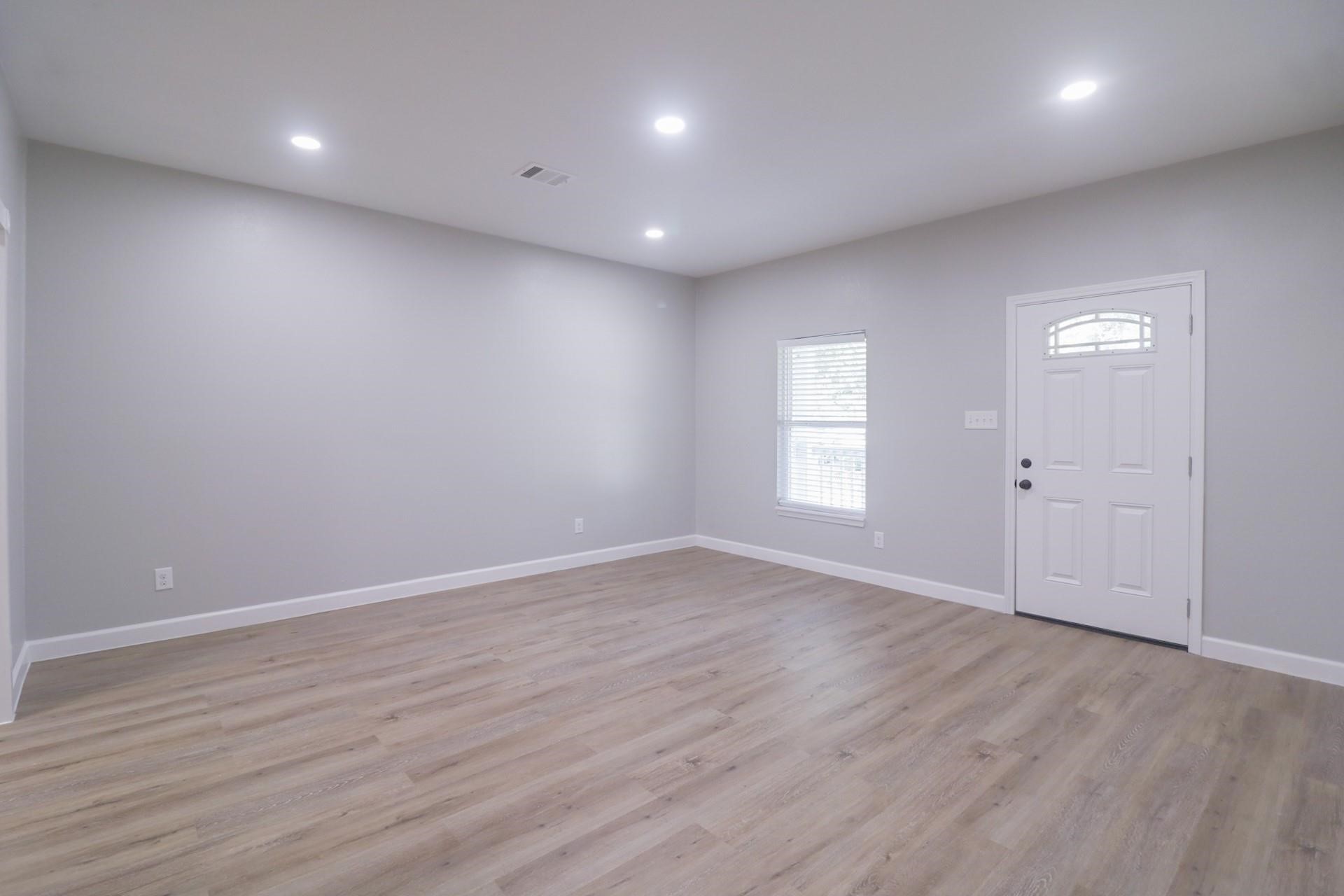 6150 Ridgeway Drive Houston, TX 77033 - Photo 22 of 36 an empty room with wooden floor and windows