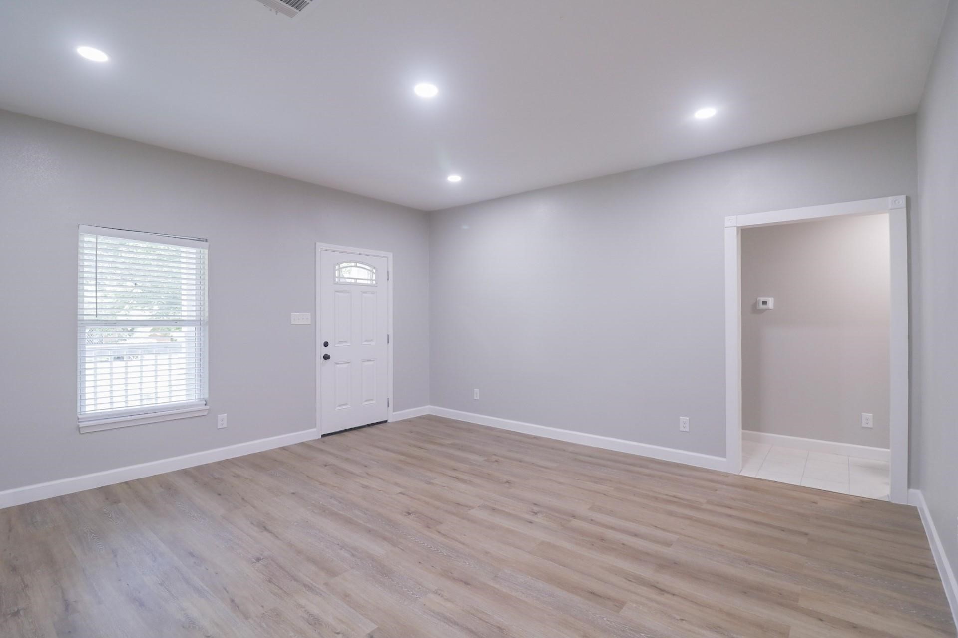 6150 Ridgeway Drive Houston, TX 77033 - Photo 24 of 36 an empty room with wooden floor and windows