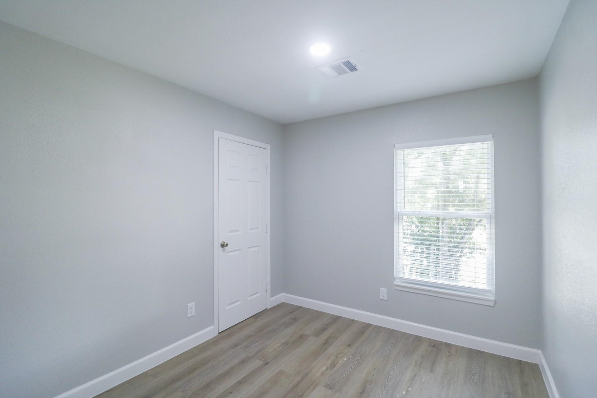 6150 Ridgeway Drive Houston, TX 77033 - Photo 30 of 36 an empty room with wooden floor and windows