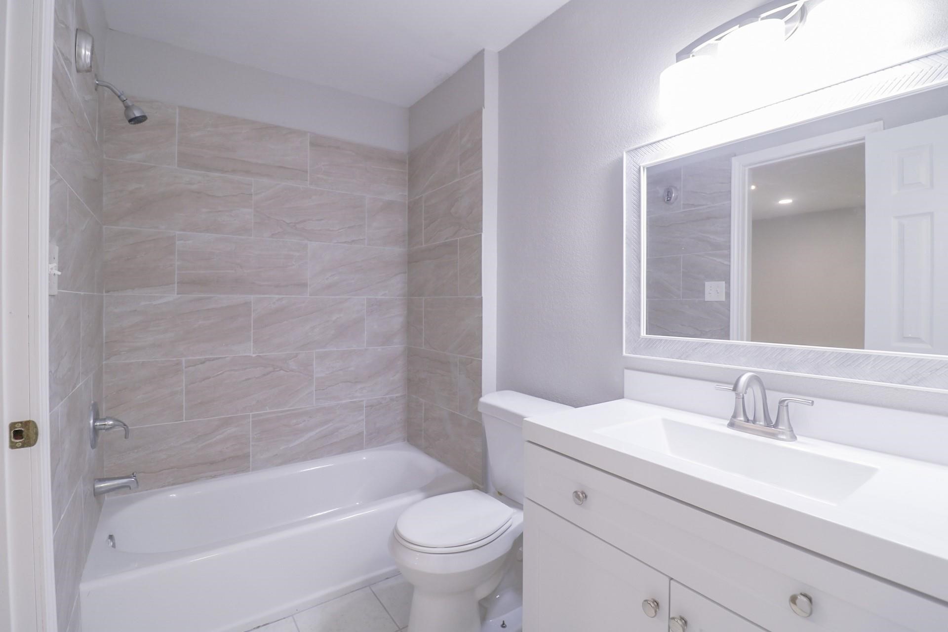 6150 Ridgeway Drive Houston, TX 77033 - Photo 9 of 36 a bathroom with a bathtub shower sink vanity mirror and toilet