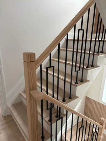 a view of staircase with railing and white walls