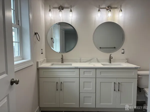 a bathroom with double vanity sinks and a mirror