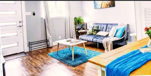 a living room with furniture wooden floor and a table