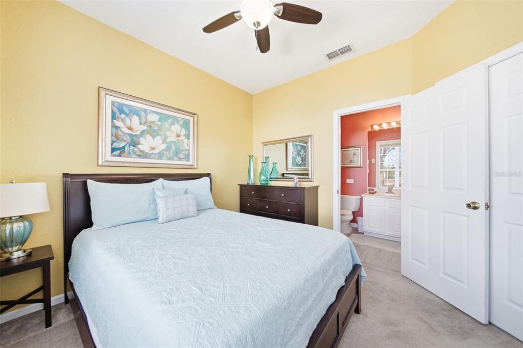 2556 Renshaw Street Kissimmee, FL 34747 - Photo 13 of 26 a bedroom with a large bed and a chandelier