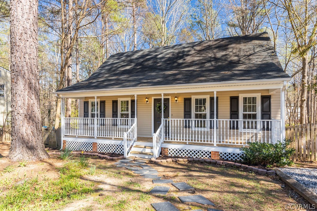 a view of a house with a small yard and wooden fence