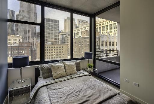 235 West Van Buren Street, Unit 3622 Chicago, IL 60607 - Photo 6 of 9 a bedroom with a bed and glass window