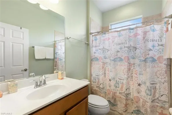 a bathroom with a sink toilet vanity and shower