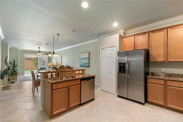 a kitchen with stainless steel appliances granite countertop a stove a sink dishwasher a refrigerator and cabinets with wooden floor