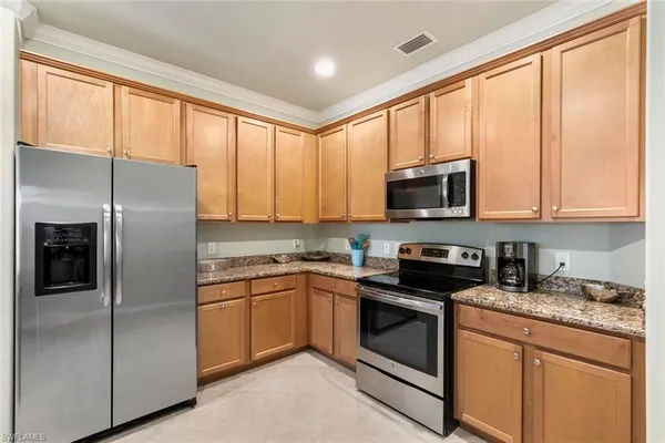 a kitchen with stainless steel appliances granite countertop a refrigerator oven a sink a stove and cabinets