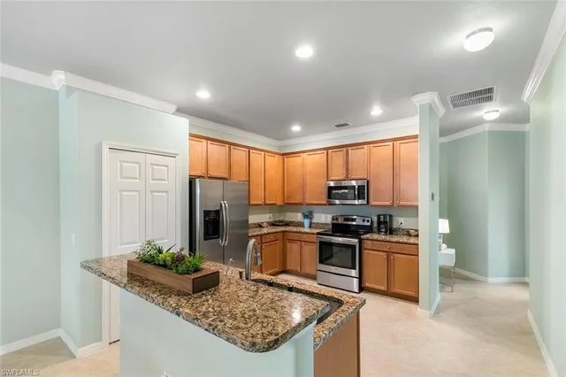 a kitchen with granite countertop a sink stove and refrigerator
