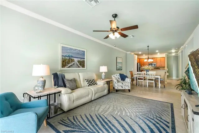 a living room with furniture a chandelier and a large window