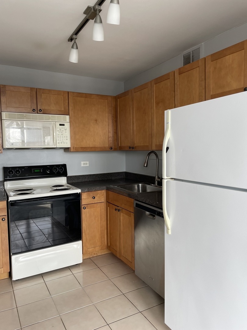 Undisclosed Address Chicago, IL 60613 - Photo 3 of 15 a kitchen with a refrigerator and a stove