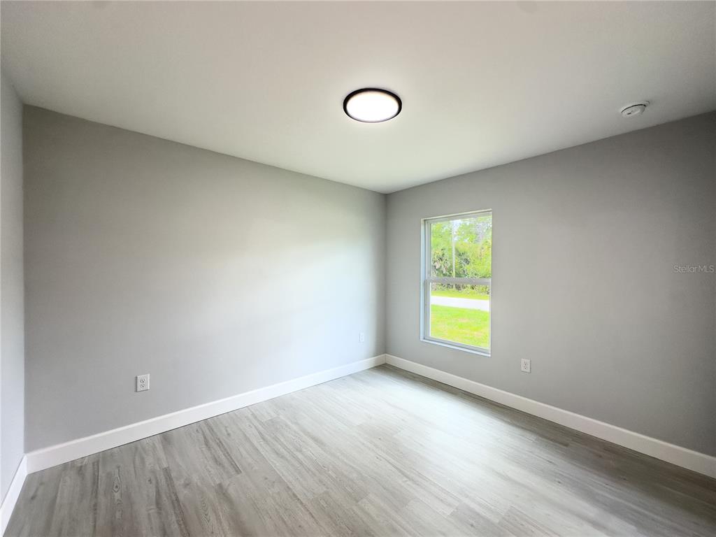 3602 Gillot Boulevard Port Charlotte, FL 33981 - Photo 14 of 28 an empty room with wooden floor and windows