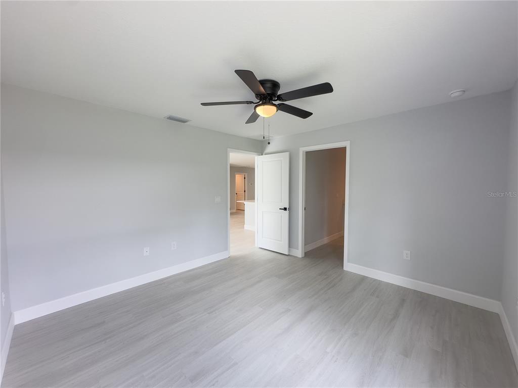3602 Gillot Boulevard Port Charlotte, FL 33981 - Photo 16 of 28 a view of a room with wooden floor and a ceiling fan